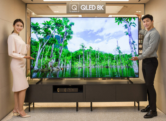 삼성전자 모델이 QLED 8K 98인치 TV를 소개하고 있다(왼쪽 사진). 모델들이 LG 시그니처 올레드 TV W 제품으로 집안 인공지능 가전을 한눈에 확인하고 제어할 수 있는 '인공지능 홈보드' 기능을 소개하고 있다.  각 사 제공